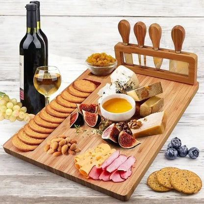 Josh & Tate - Serving Board Set with Built-In Knife Holder - Wooden charcuterie board with assorted cheeses, meats, fruits, and crackers on a wooden surface.