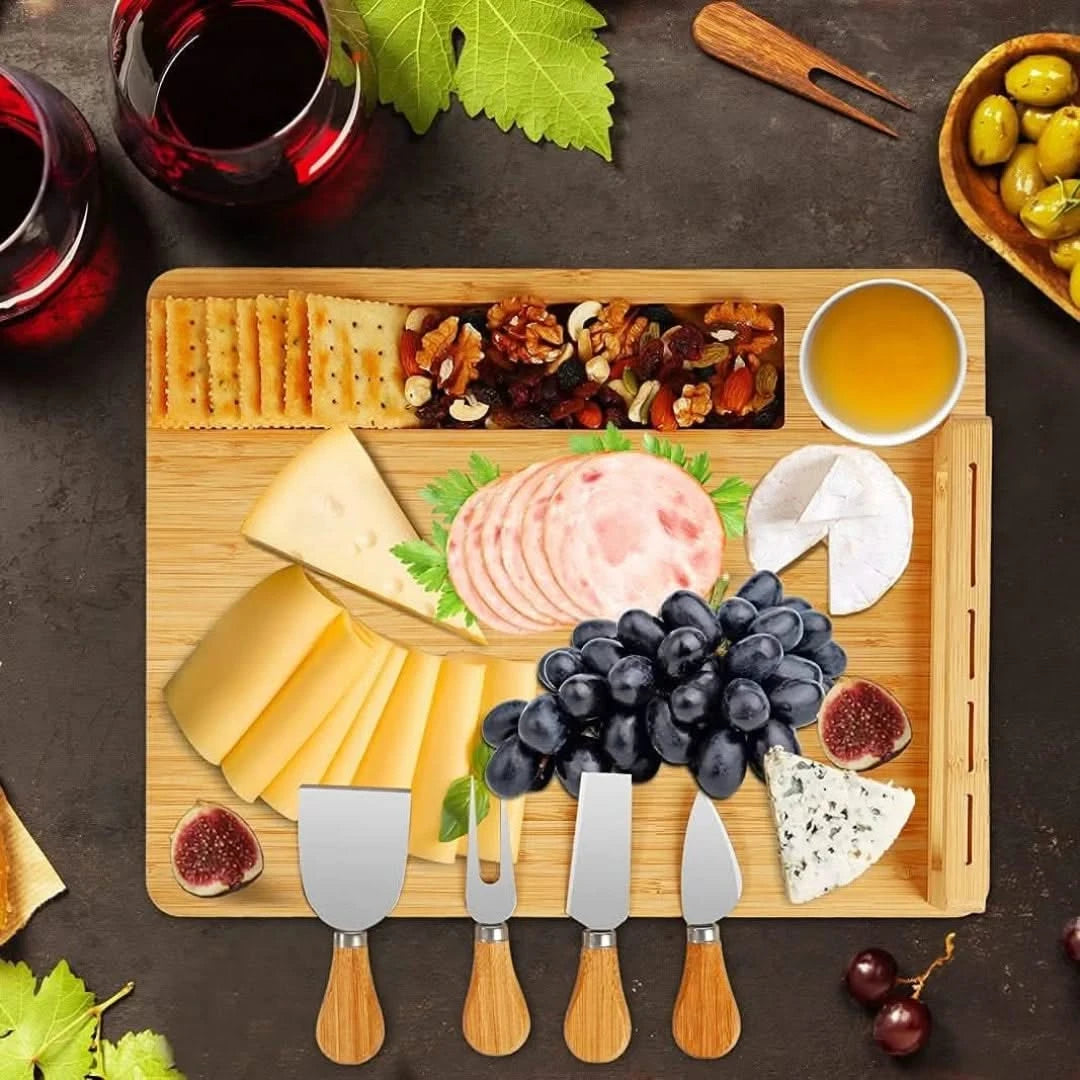 Josh & Tate - Serving Board Set with Built-In Knife Holder - Wooden charcuterie board with assorted cheeses, meats, fruits, and crackers on a dark surface.