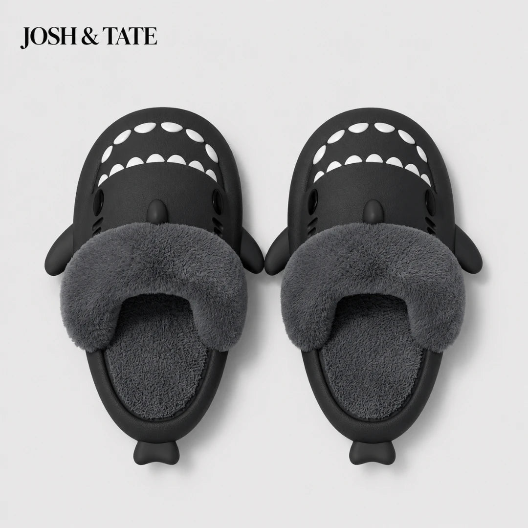 Josh & Tate - SharkStep™ Plush Slip-On Slipper - Black shark-shaped slippers with gray fur interior on a light gray background, featuring the brand 'Josh & Tate'.
