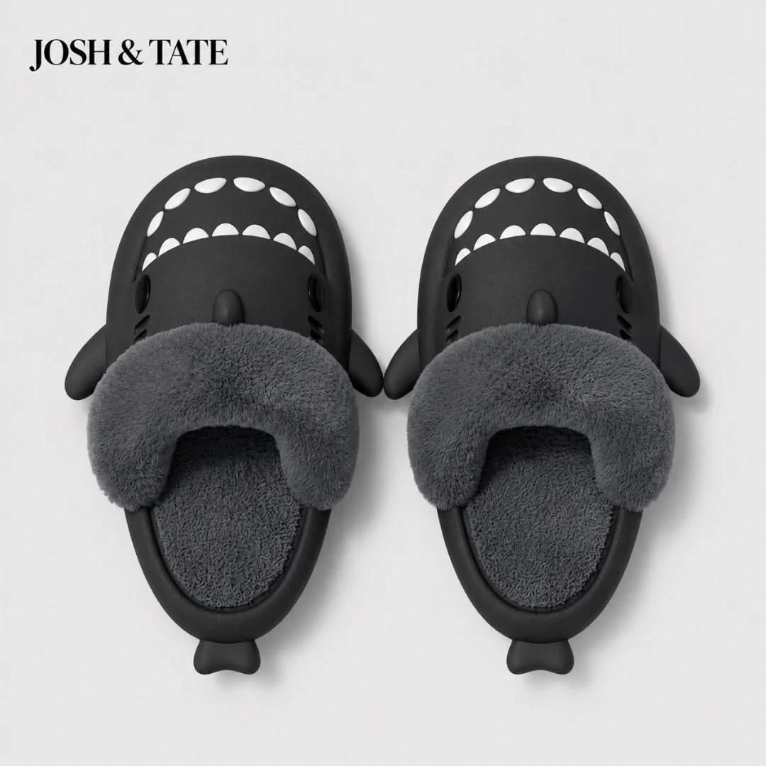 Josh & Tate - SharkStep™ Plush Slip-On Slipper - Black shark-shaped slippers with gray fur interior on a light gray background, featuring the brand 'Josh & Tate'.