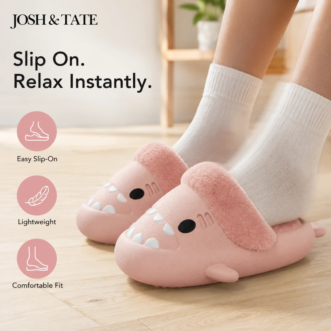 Josh & Tate - SharkStep™ Plush Slip-On Slipper - Pink slippers with cartoon design worn by a person, on a light wooden floor.