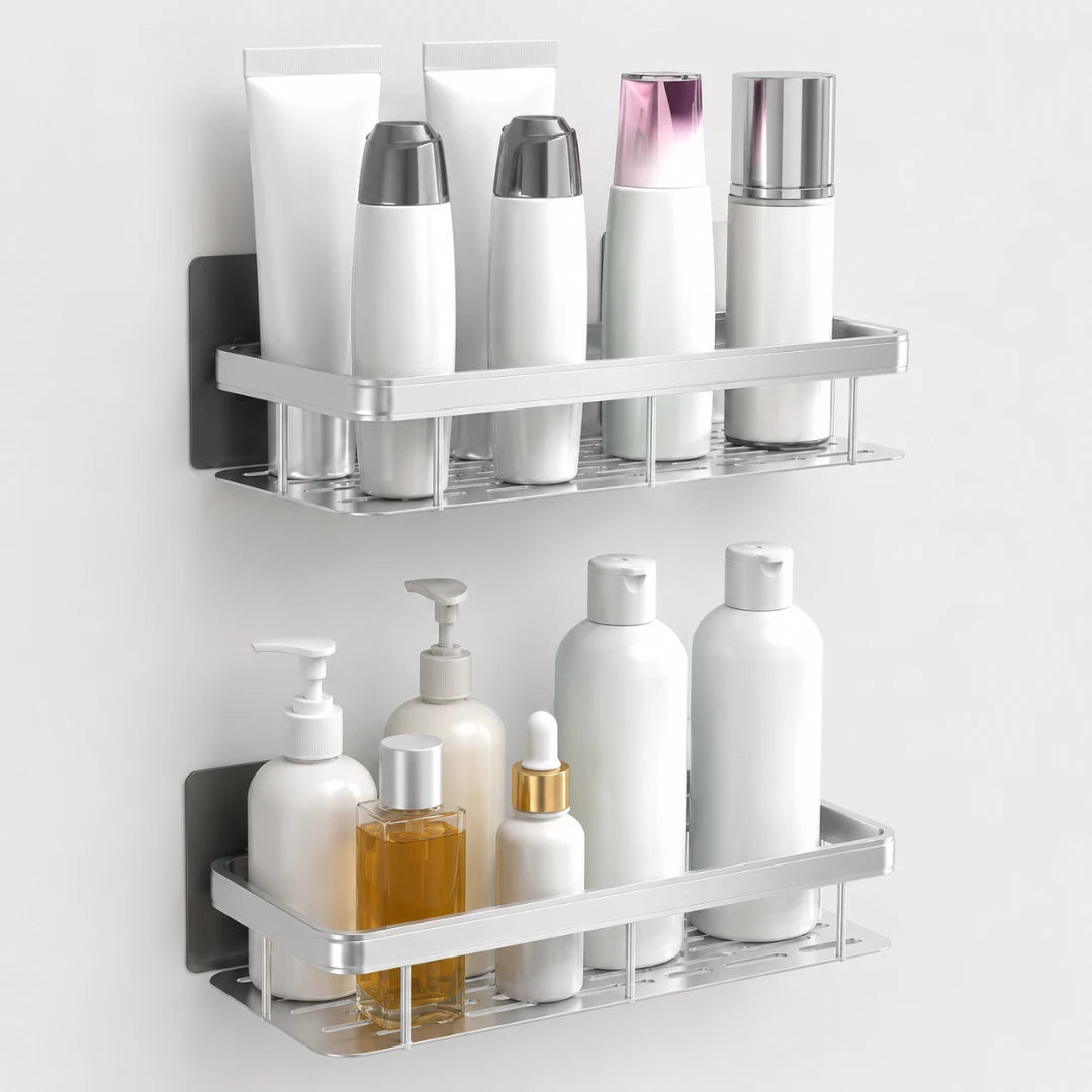 Josh & Tate - ShelfLoft™ Adhesive Shower Shelf - Two wall-mounted chrome bathroom shelves holding assorted toiletries, including white bottles, tubes, and a small amber bottle, against a plain light wall.