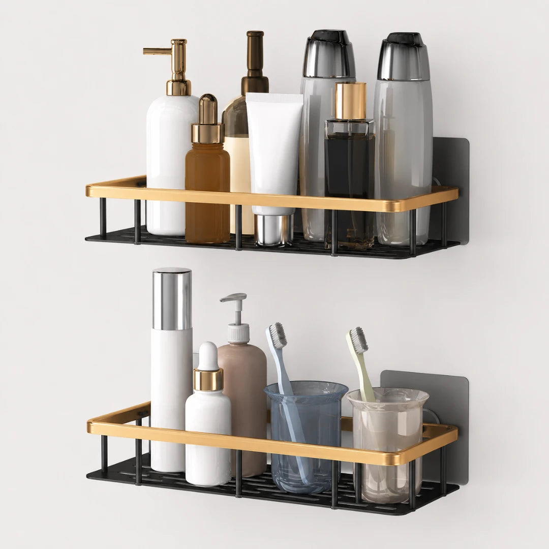 Josh & Tate - ShelfLoft™ Adhesive Shower Shelf - Two wall-mounted bathroom shelves with black metal frames and gold-toned horizontal bars, shown holding toiletry bottles, toothbrushes, cups, and other bathroom accessories against a light gray wall.