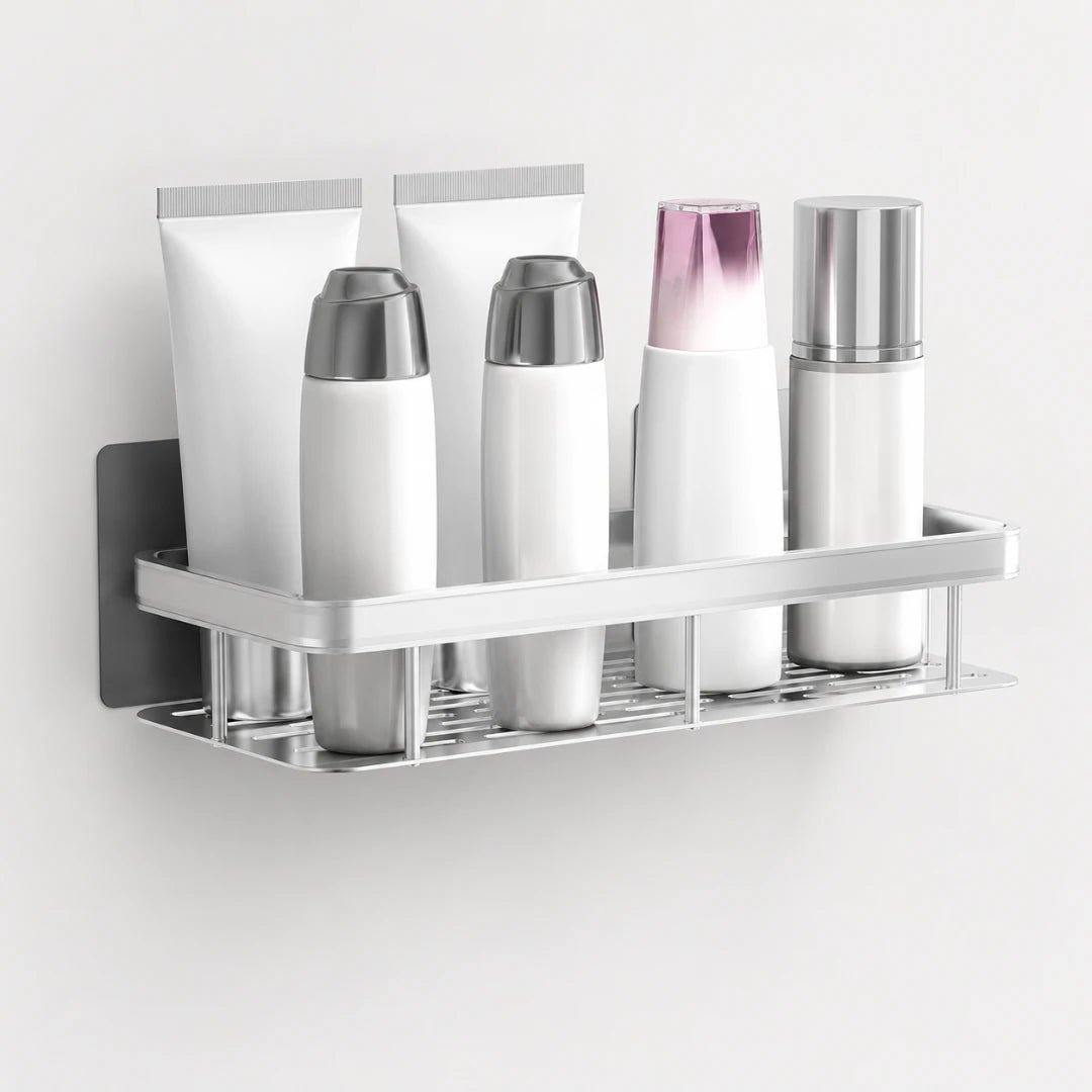 Josh & Tate - ShelfLoft™ Adhesive Shower Shelf - A wall-mounted stainless steel bathroom toiletry organizer holding four white cosmetic bottles and two white tubes against a plain light wall.