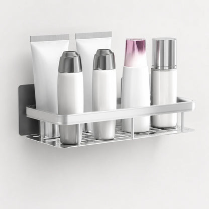 Josh & Tate - ShelfLoft™ Adhesive Shower Shelf - A wall-mounted stainless steel bathroom toiletry organizer holding four white cosmetic bottles and two white tubes against a plain light wall.