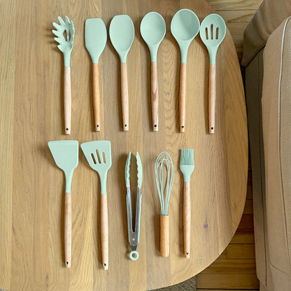 Set of kitchen utensils with wooden handles on a wooden surface