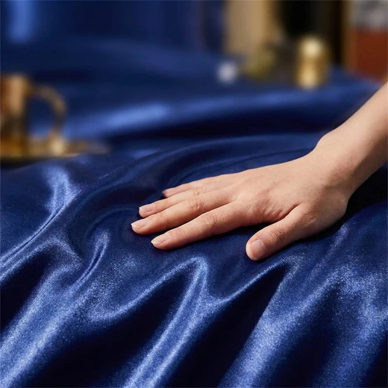 Hand touching blue satin fabric with a blurred background