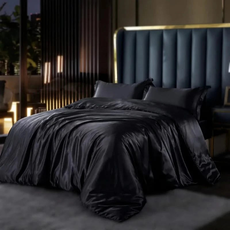 Dark gray bedding on a bed with a modern headboard in a dimly lit room.