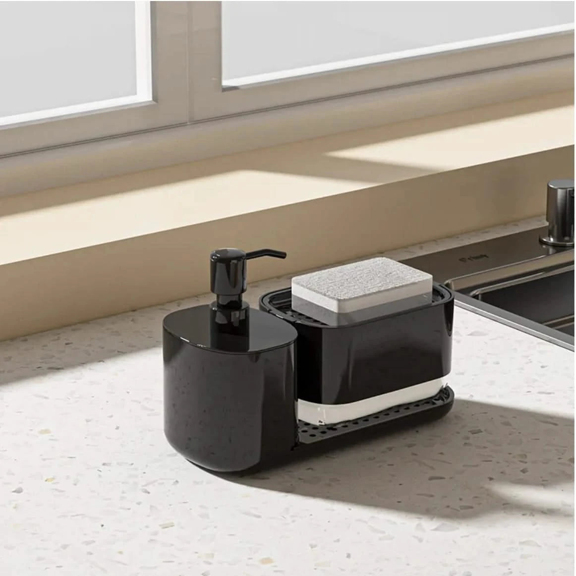Black kitchen sink caddy with soap dispenser and sponge holder on a countertop.