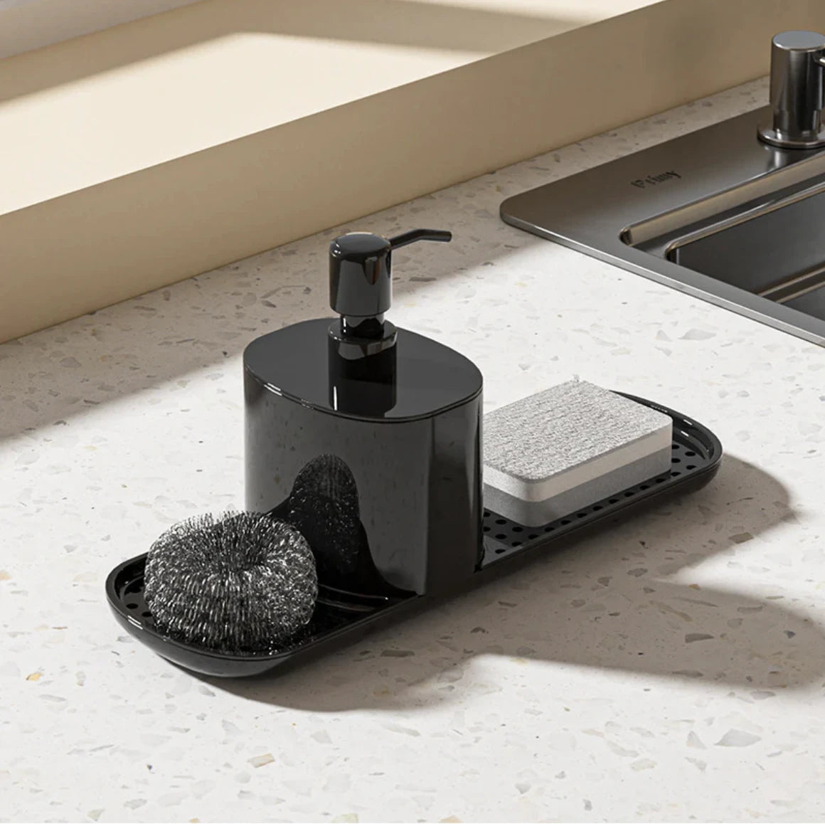 Black dishwashing set with soap dispenser, scrubber, and sponge on a kitchen counter.