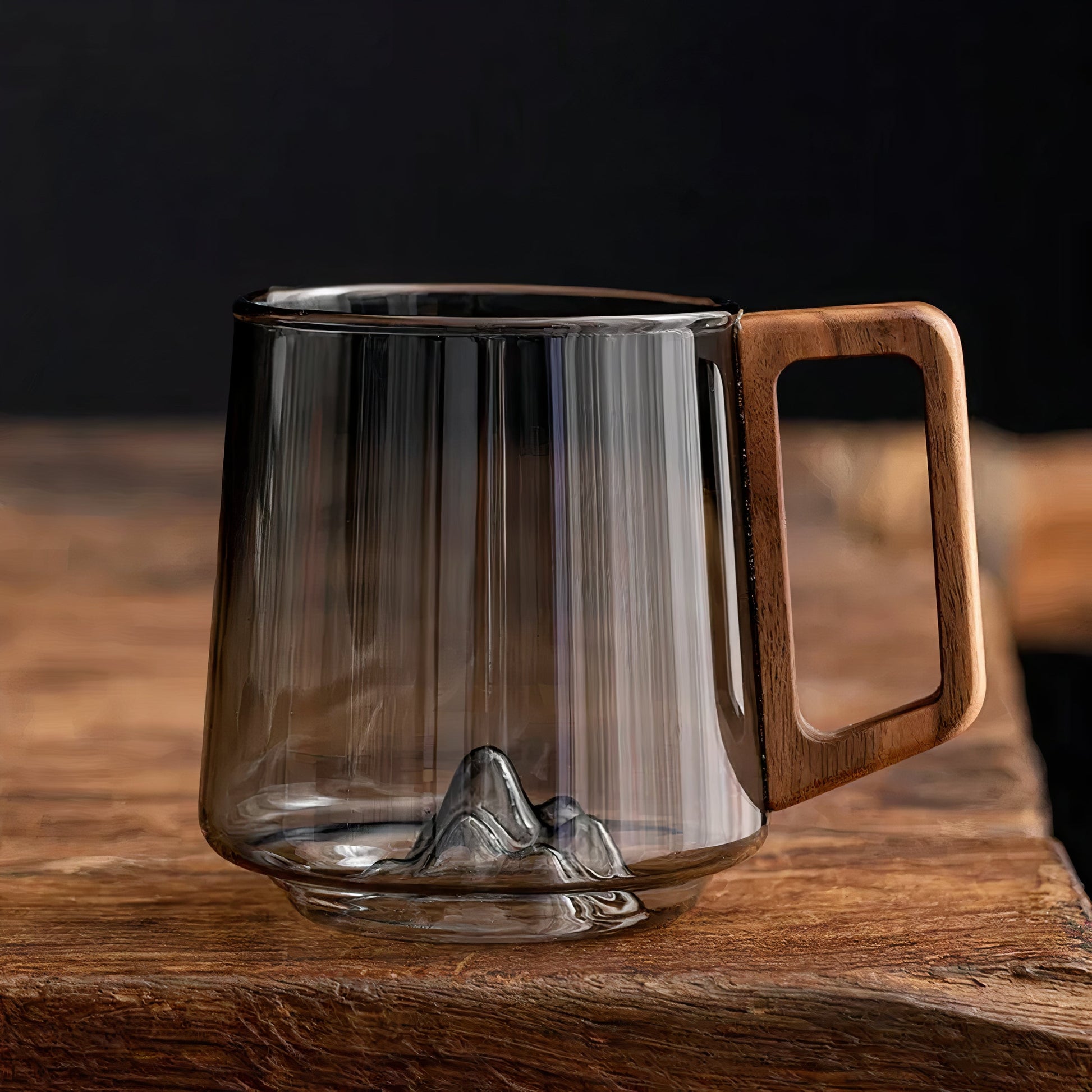 Clear glass mug with wooden handle on a wooden surface