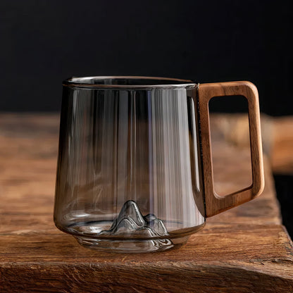 Clear glass mug with wooden handle on a wooden surface