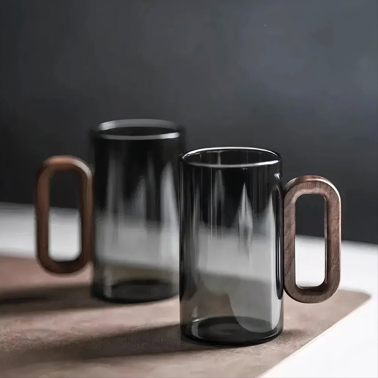Two black glass mugs with wooden handles on a dark background