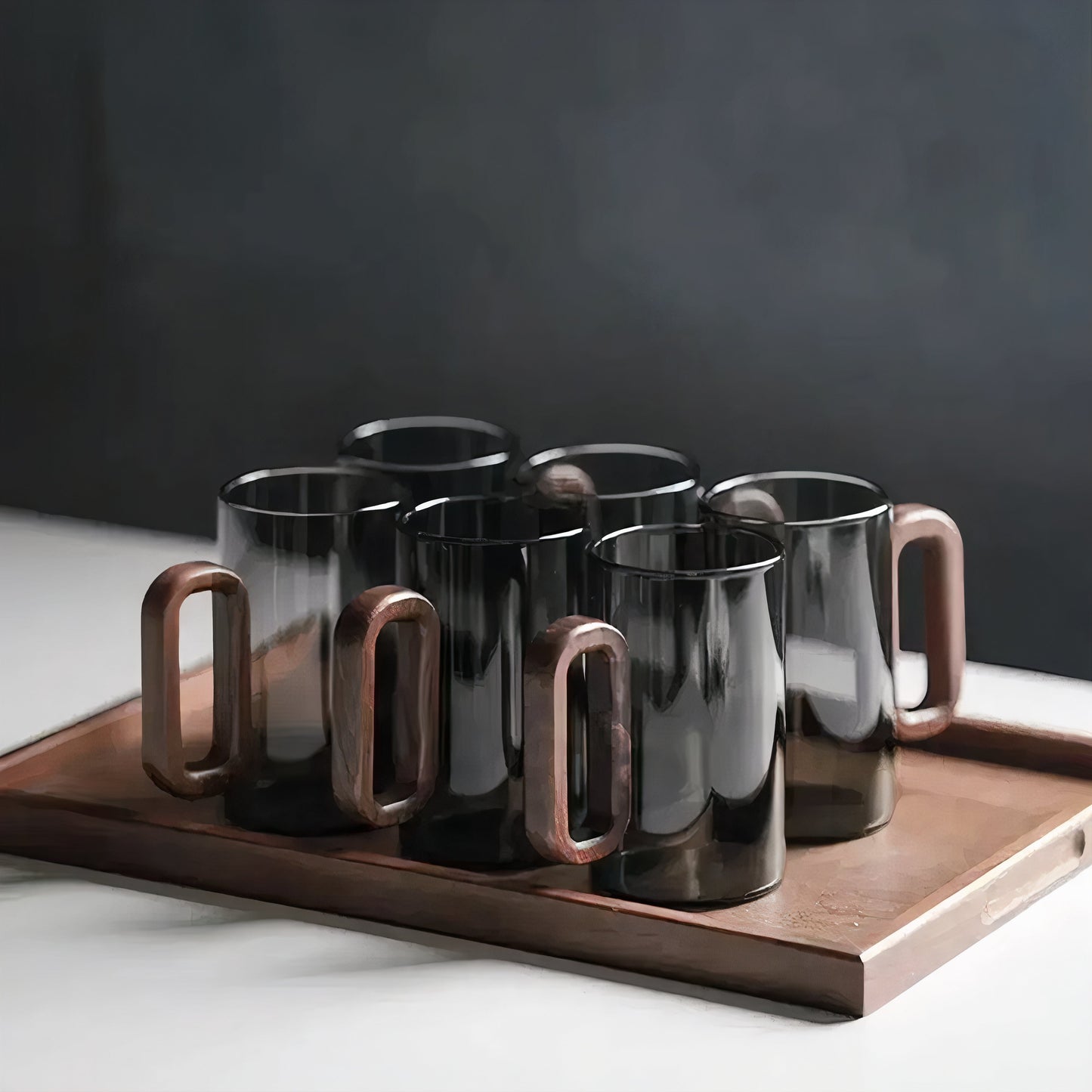 Set of black mugs with wooden handles on a wooden tray against a dark background