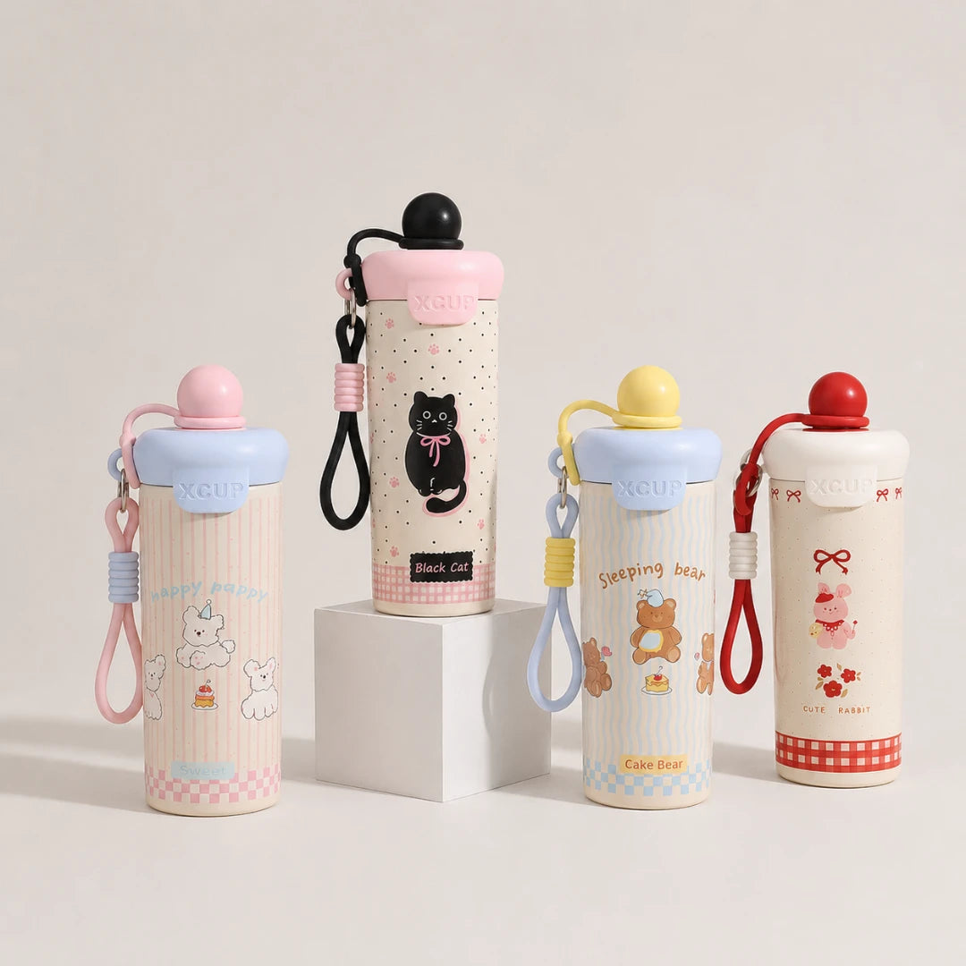Josh & Tate - SnugPop™ Cute Insulated Tumbler - Four insulated water bottles with carrying straps and lids, displayed on a clean white studio background with one bottle resting on a white pedestal. The bottles feature cute cartoon designs including a black cat, teddy bears, and a pig, with pastel pink, blue, yellow, and red accents.