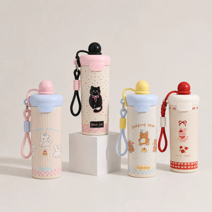 Josh & Tate - SnugPop™ Cute Insulated Tumbler - Four insulated water bottles with carrying straps and lids, displayed on a clean white studio background with one bottle resting on a white pedestal. The bottles feature cute cartoon designs including a black cat, teddy bears, and a pig, with pastel pink, blue, yellow, and red accents.