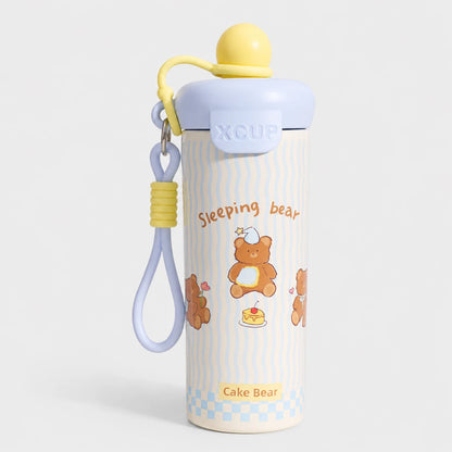 Josh & Tate - SnugPop™ Cute Insulated Tumbler - A cute stainless steel water bottle with a lid, featuring a cartoon teddy bear design and the text 'Sleeping bear' and 'Cake Bear'. It has a light blue lid, a yellow cap, and a matching light blue and yellow wrist strap, set against a light gray background.