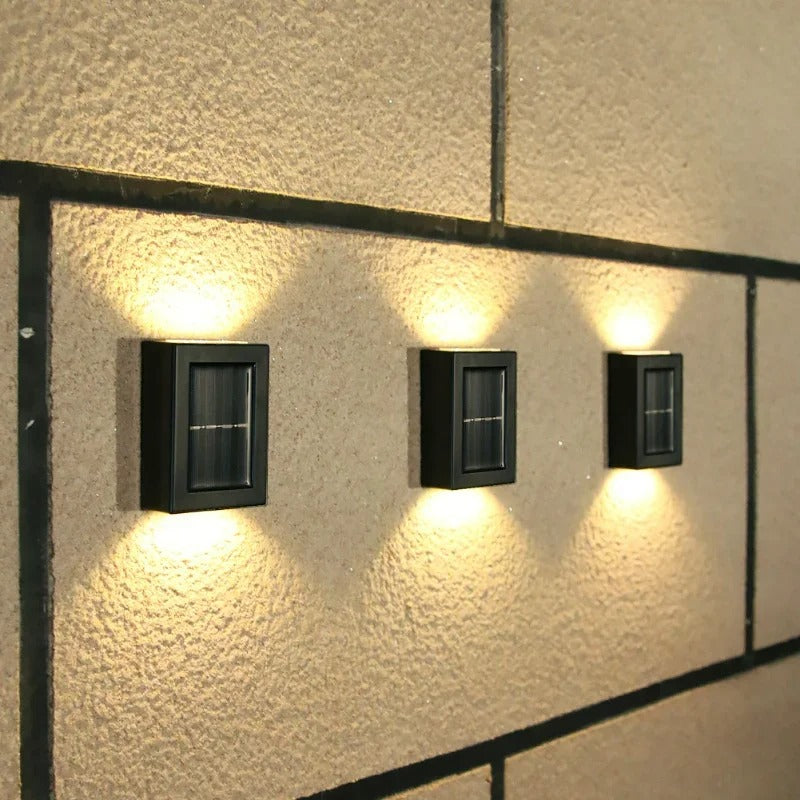 Three wall-mounted outdoor lights on a textured wall.