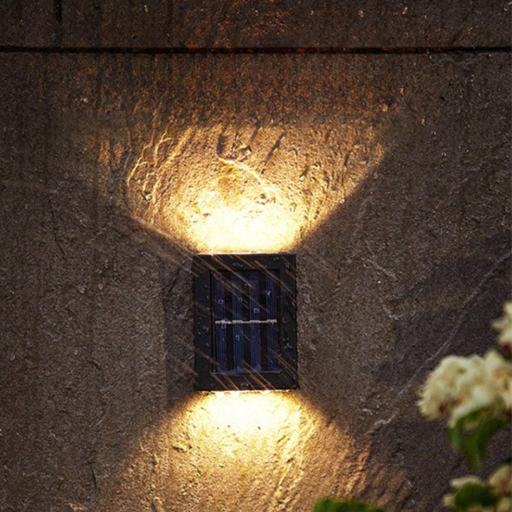 Solar-powered outdoor wall light fixture on a textured stone wall.