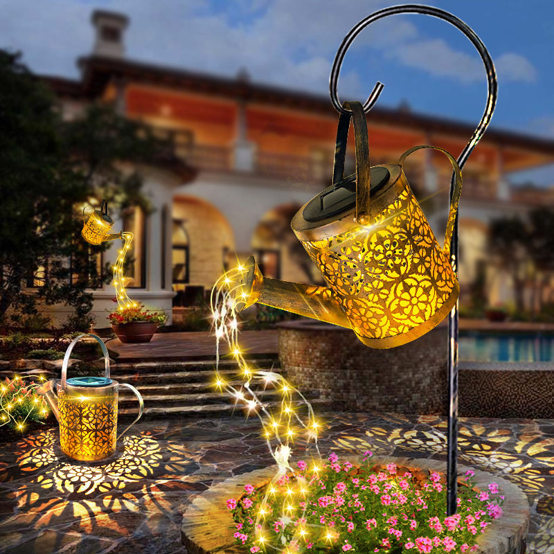 Solar-powered teapot light with string lights in a garden setting