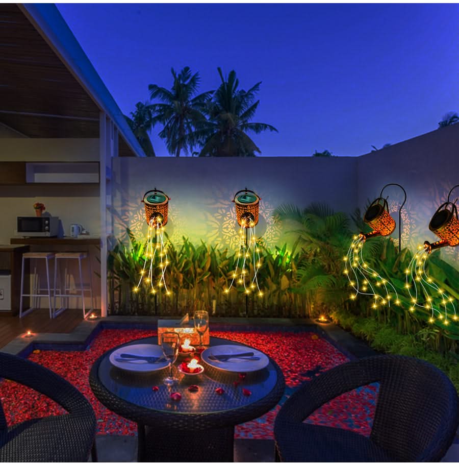 Dining area with string lights, plates, and candles on a patio at night.