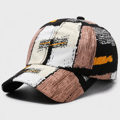 Josh & Tate - SplashPatch™ Graffiti Cap - A baseball cap with a modern abstract patchwork pattern in black, white, dusty pink, and orange, shown on a light gray background.