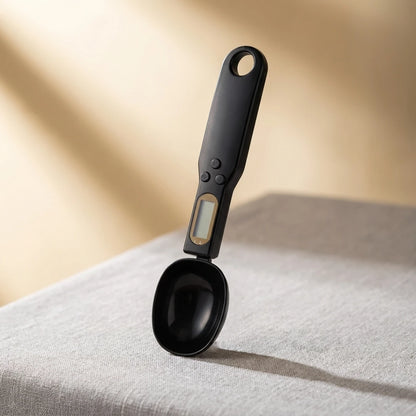 Josh & Tate - SpoonScale™ Smart Measuring Spoon -Black digital measuring spoon on a textured surface with a neutral background