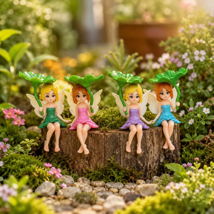 Josh & Tate - SproutPixie™ Leaf Umbrella Pixie Car Ornament - Four small fairy figurines with wings and flower-shaped hats sit on a tree stump in a garden setting with flowers, moss, and stones.