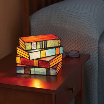 Stack of colorful books lamp on a wooden surface with a blurred chair in the background