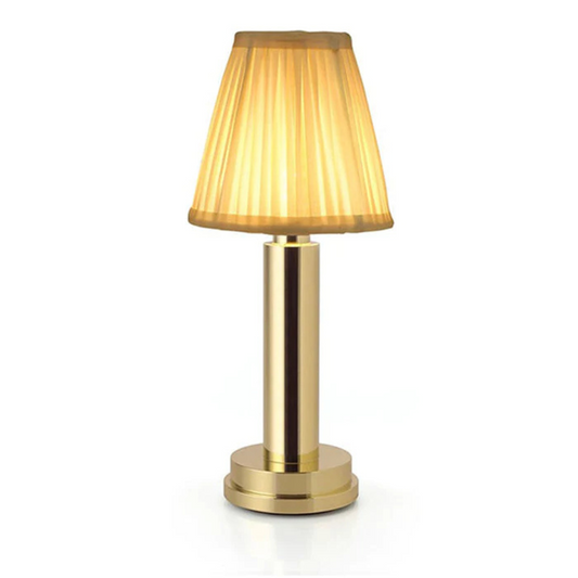 Gold table lamp with pleated shade on a white background