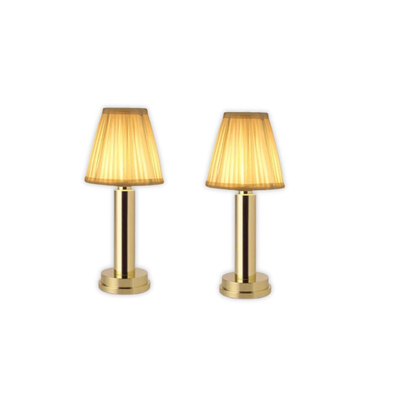 Two gold table lamps with pleated shades on a white background