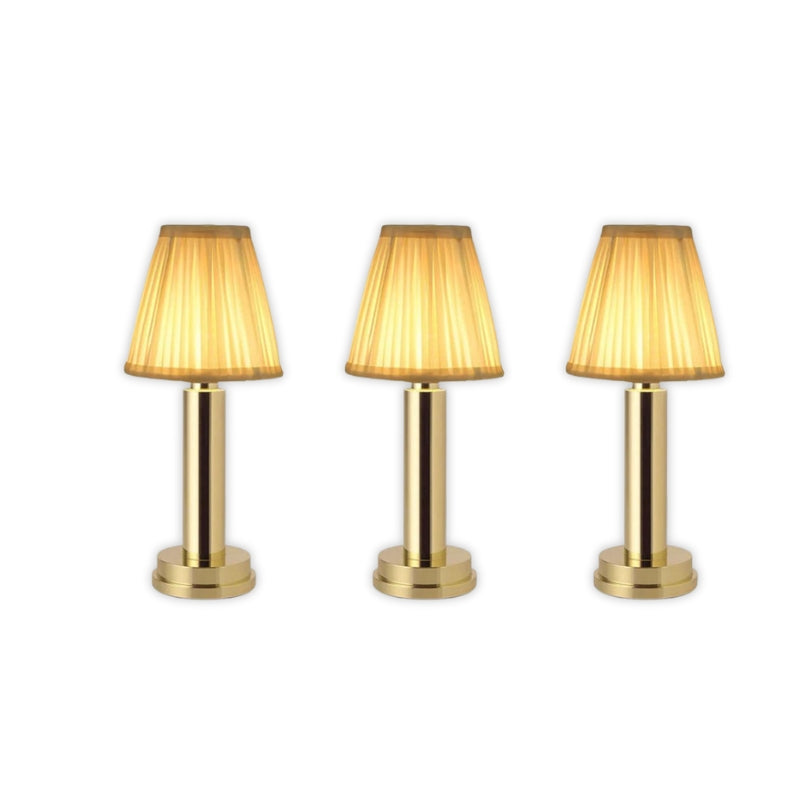 Three gold table lamps with pleated shades on a white background