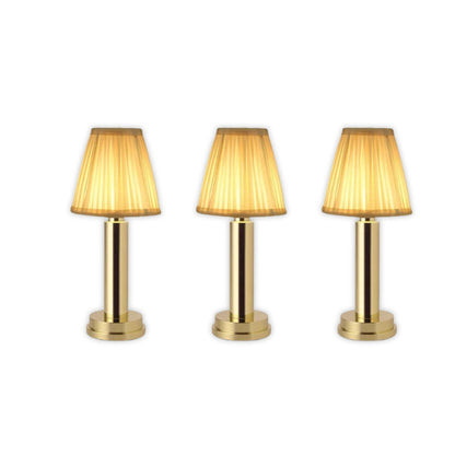 Three gold table lamps with pleated shades on a white background
