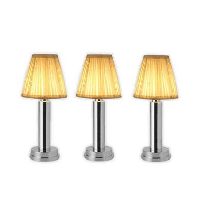 Three table lamps with gold lampshades on a white background