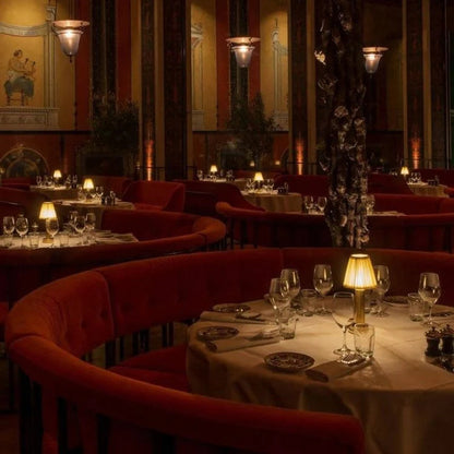 Dining area with red chairs and lit lamps in a restaurant setting