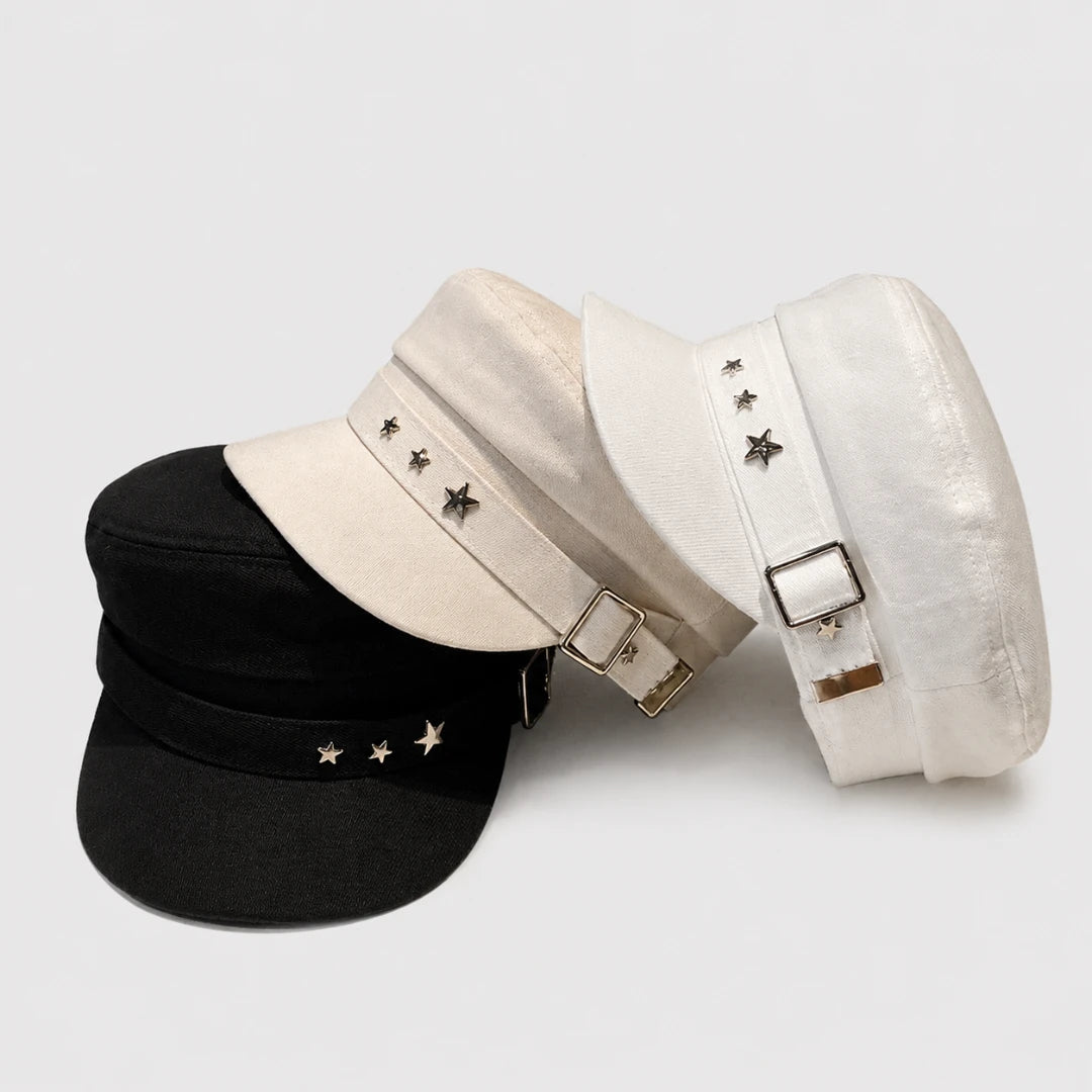 Josh & Tate - StarHat™ Retro Beret - Three military-style peaked caps arranged on a light gray background: one black cap in front, and two white capstoeks behind it with metal buckle straps and star embellishments.