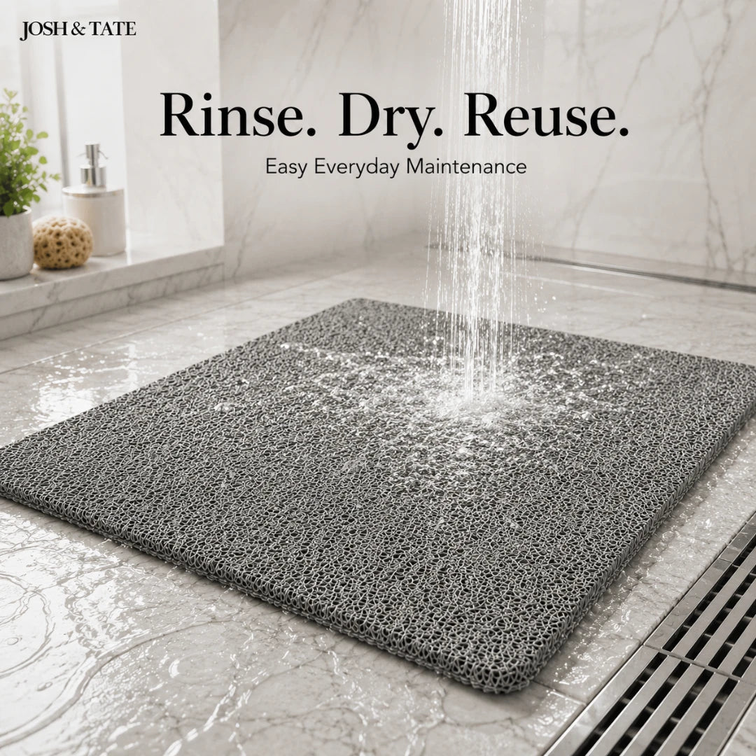 Josh & Tate - StepDry™ Anti-Slip Bath Mat - Gray bath mat on a bathroom floor with water being rinsed over it, featuring 'Josh & Tate' branding.