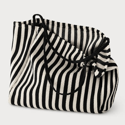 Josh & Tate - StripeCarry™ Oversized Tote Bag - A black and white vertically striped woven tote bag with black drawstring handles, shown on a light gray background.
