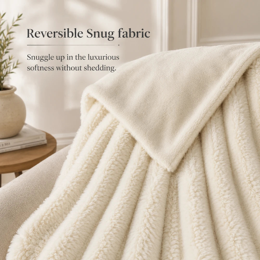Beige blanket draped over a surface with text about reversible snug fabric.