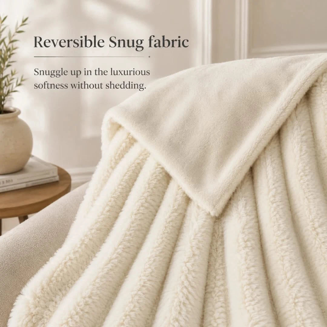 Beige blanket draped over a surface with text about reversible snug fabric.