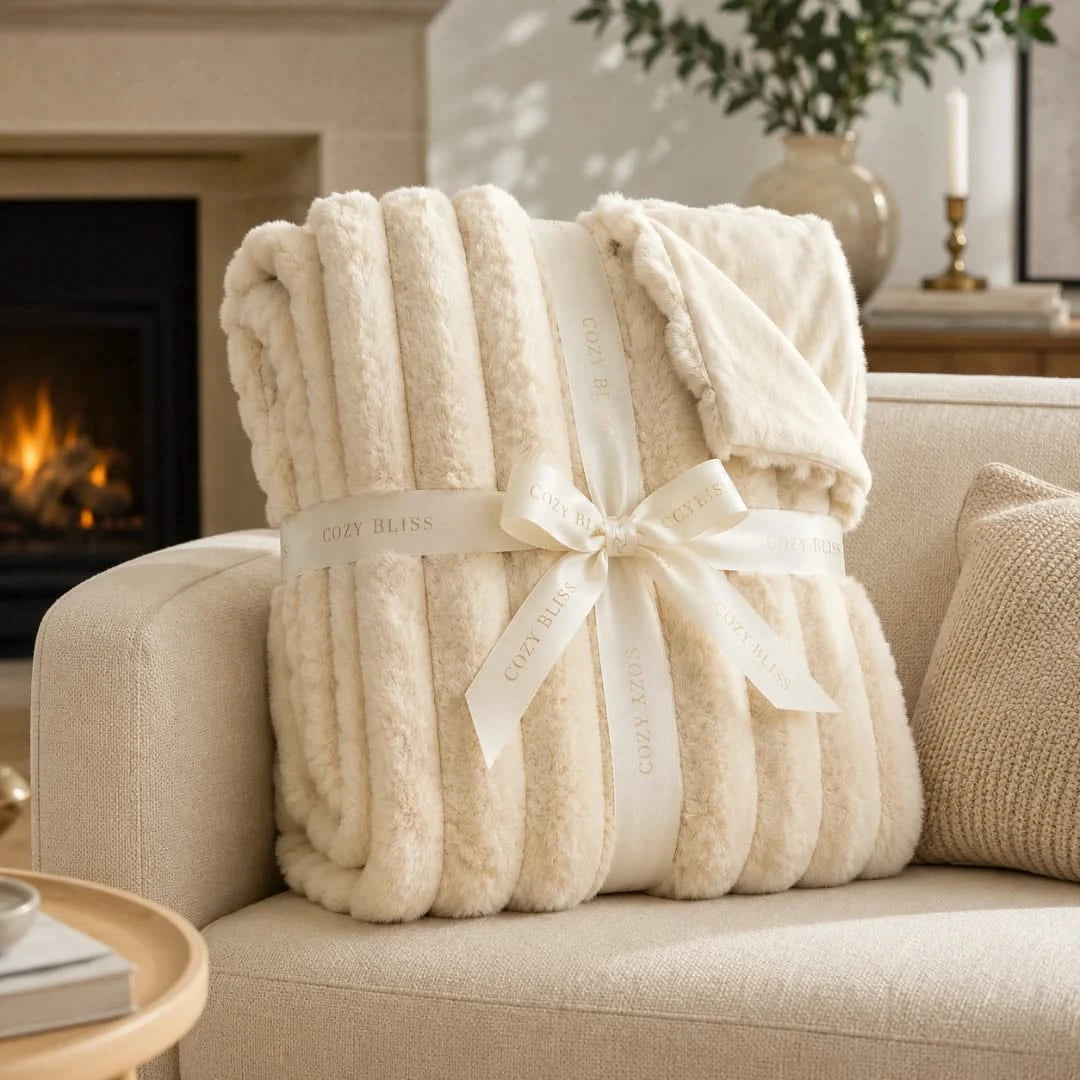 Beige blanket with a bow on a beige sofa in a cozy living room.
