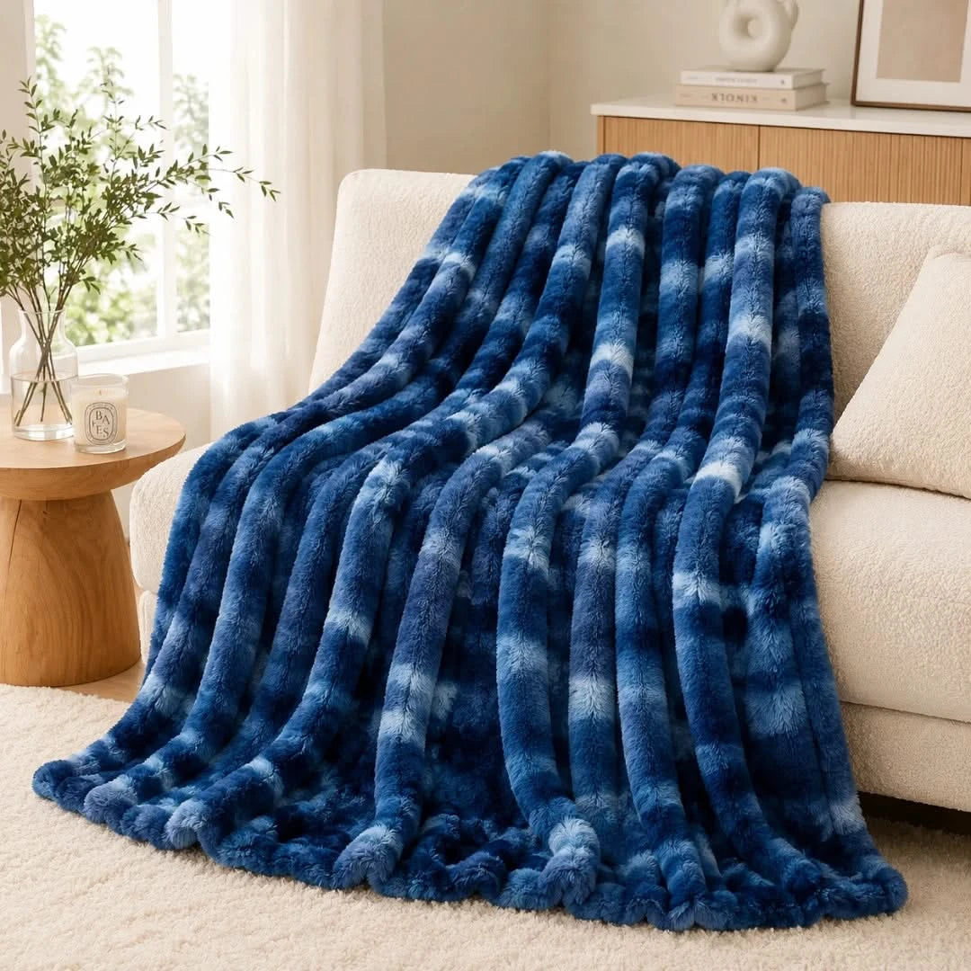 Blue checkered blanket draped over a beige sofa in a living room setting.