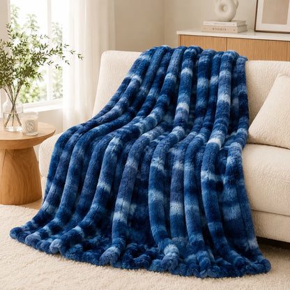 Blue checkered blanket draped over a beige sofa in a living room setting.