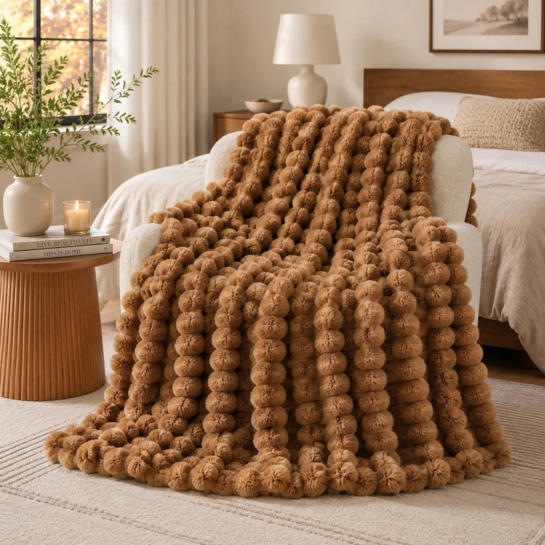 Brown textured blanket draped over a bed in a cozy bedroom setting.