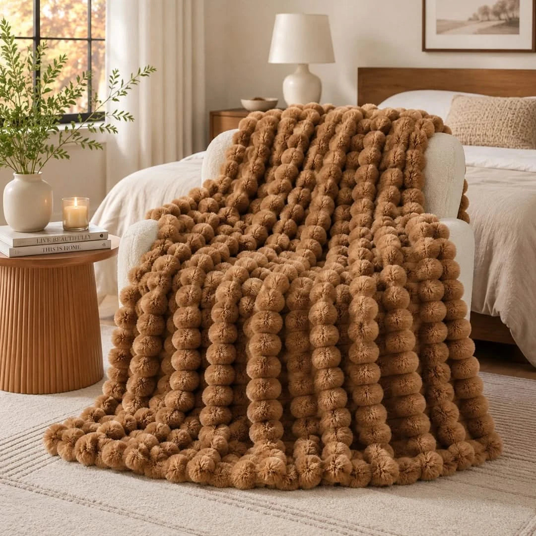 Brown textured blanket draped over a bed in a cozy bedroom setting.
