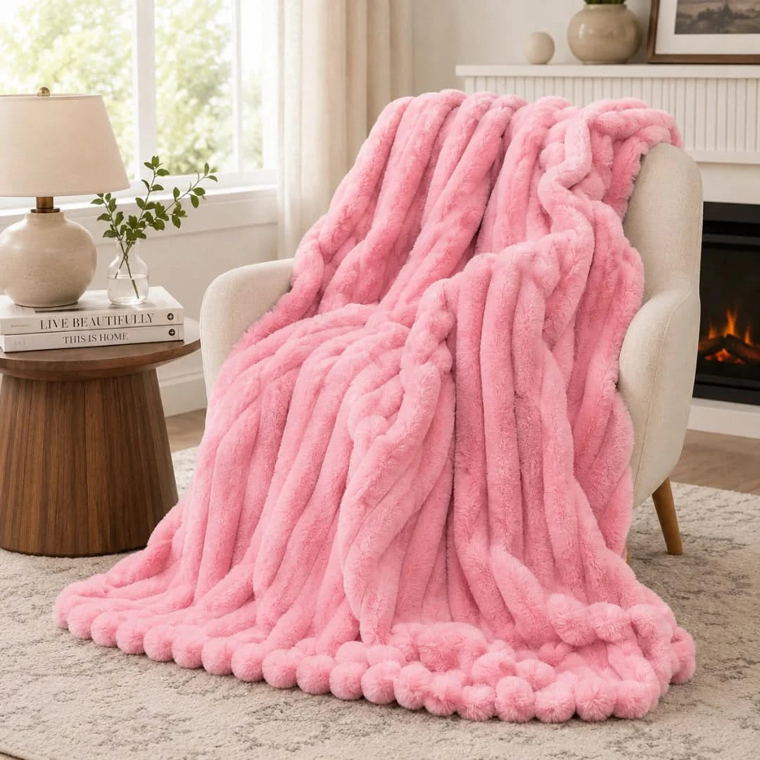 Pink fluffy blanket draped over a chair in a cozy living room.