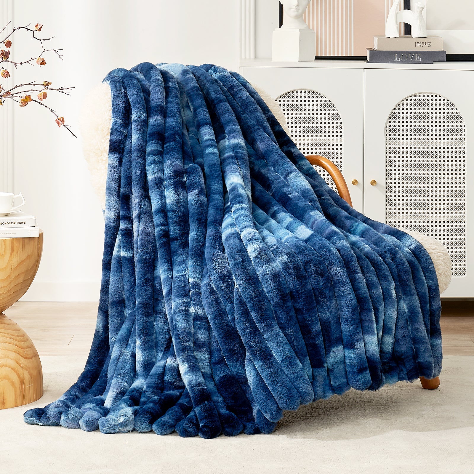 Blue textured blanket draped over a chair in a room with a cabinet and decorative items.