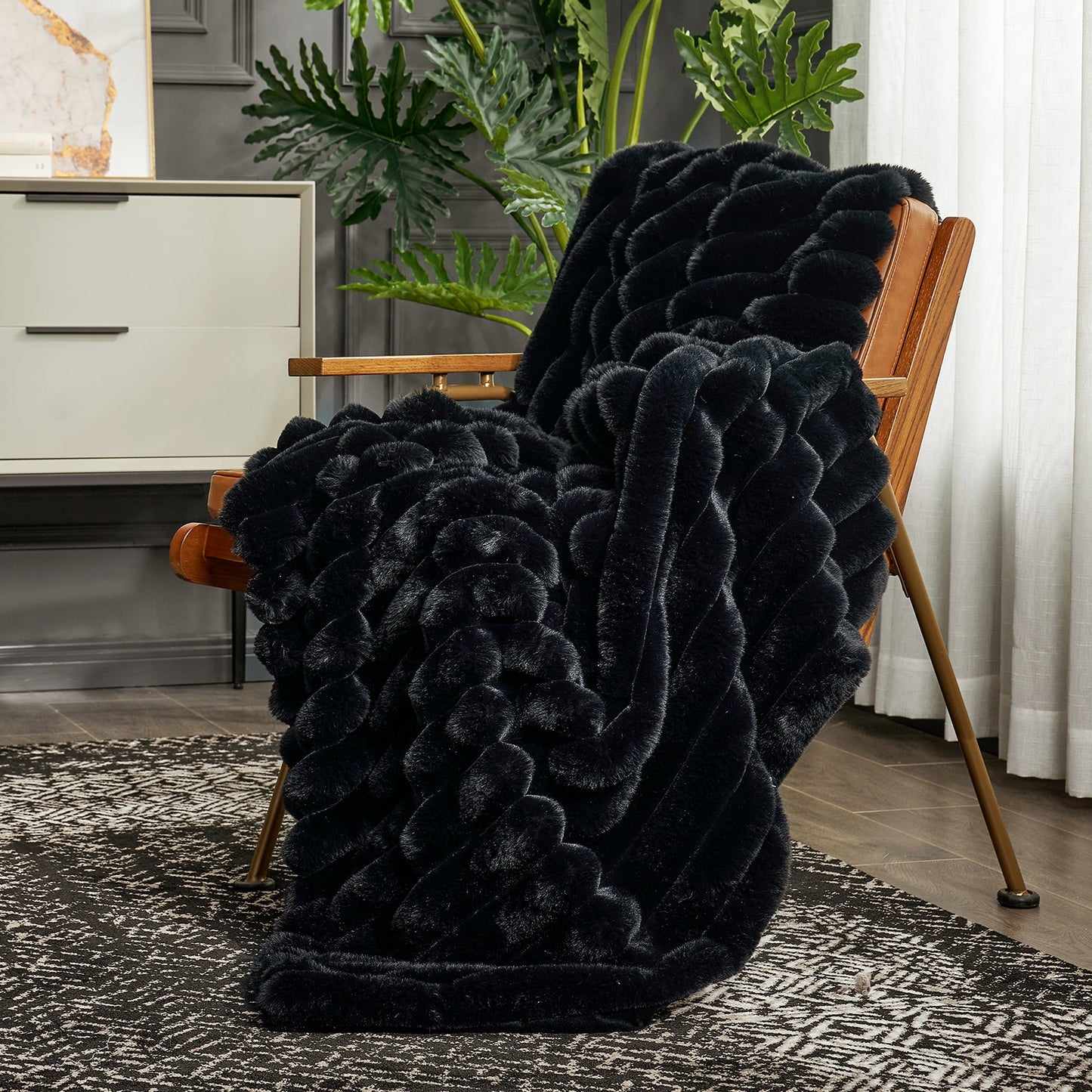 Black faux fur blanket draped over a wooden chair in a room with plants and a cabinet.