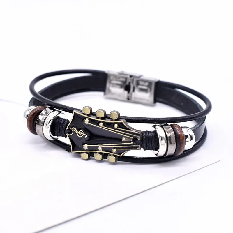 Black leather bracelet with guitar pick and music note design on a white background