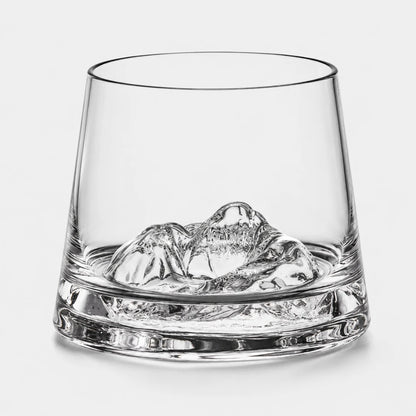 Josh & Tate - SummitRock™ Crystal Whiskey Glass - A clear glass rocks tumbler with a sculpted mountain-shaped ice piece inside, photographed on a clean light gray background.